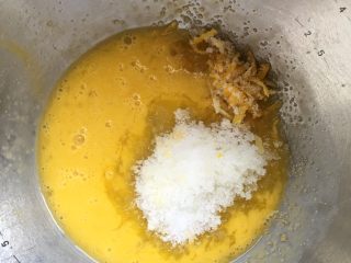 猫爪蛋糕,把鸡蛋打进盆里，然后把柠檬皮屑和细砂糖倒入，搅拌均匀