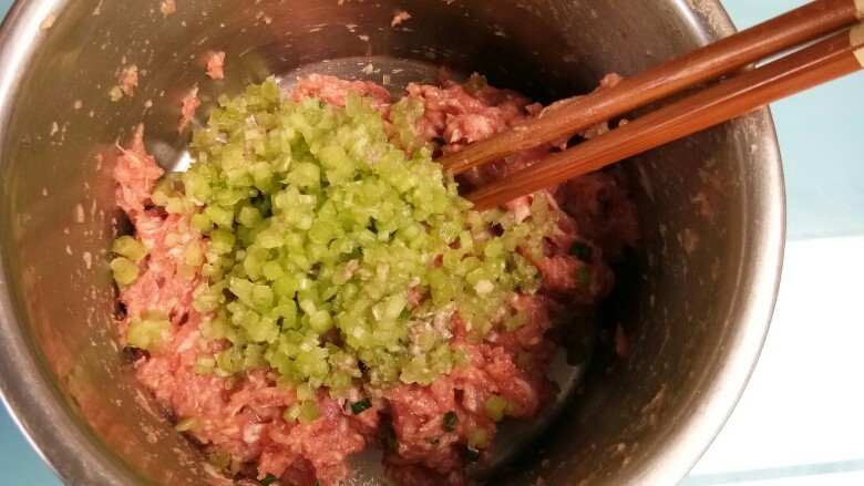 酿南瓜花,把切碎的花梗倒入腌好的肉末中搅拌均匀