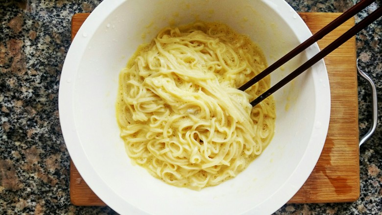 鲜香素炒面,用筷子搅拌均匀，让每一根面条都粘上蛋液。这样炒出的面条金黄可口，而且营养丰富呢。