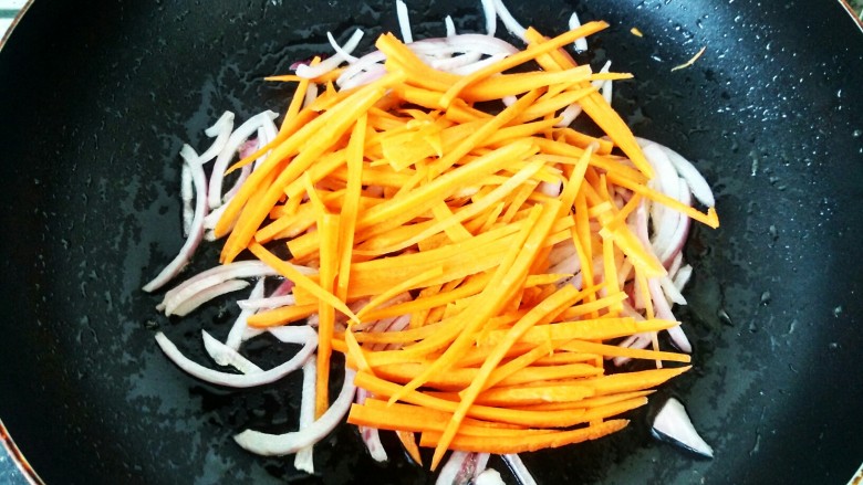 鲜香素炒面,把洋葱炒香后，下入胡萝卜继续翻炒。