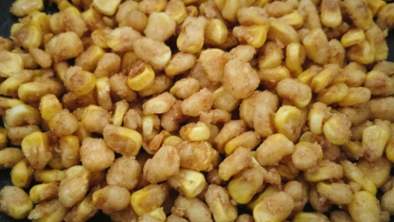 金沙玉米粒,快速搅拌均匀，我个人的喜好是再加一点点儿的白糖和花椒粉。