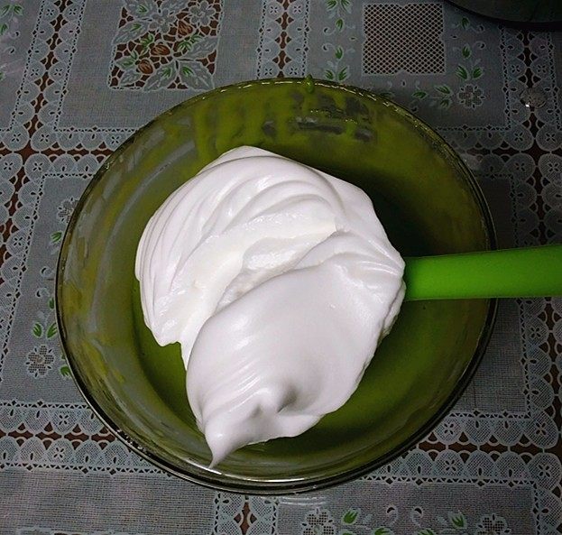 菠菜汁戚风蛋糕,取1/3蛋白至蛋黄糊中翻拌均匀