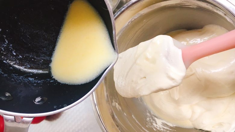 不塌陷杯子蛋糕,将牛奶黄油混合液缓缓倒入蛋盆内，翻拌均匀