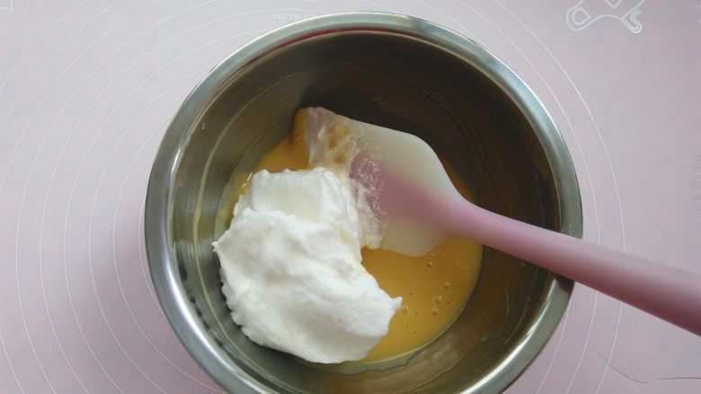 不回缩的迷你小纸杯戚风蛋糕,取三分之一蛋白霜放入蛋黄糊，2-8点钟方向手法翻拌均匀
