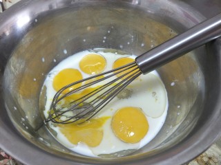 8寸戚风蛋糕,分离的蛋黄加入牛奶，玉米油，白糖19克，用手动抽打均匀。