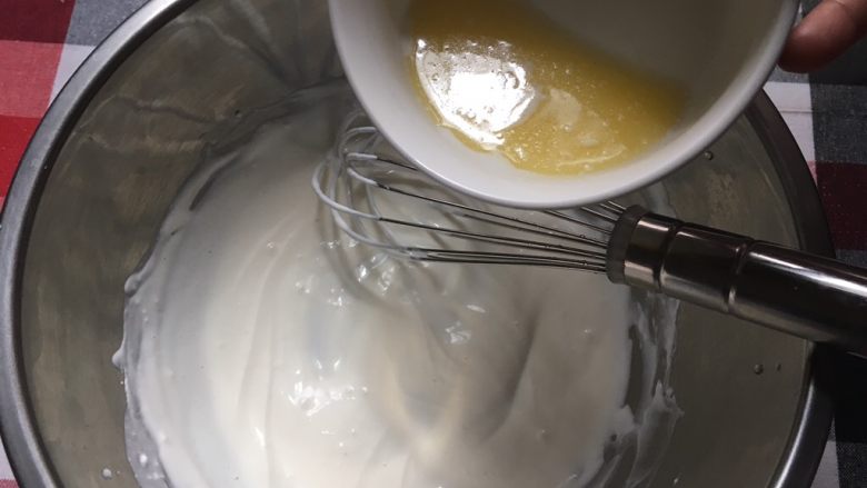 花朵轻芝士蛋糕,直至奶酪与牛奶混合均匀，出现小纹路时，加入液化好的黄油，分3次加入