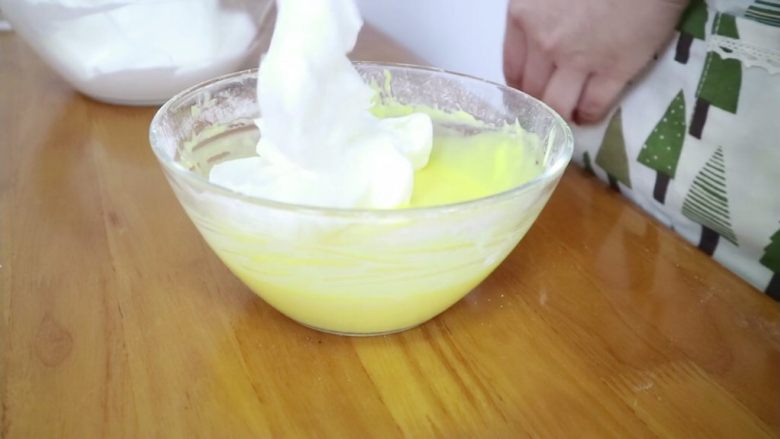 百香果酸奶小纸杯,我分两次混合的蛋黄糊与蛋白霜
先加1/2的蛋白霜到蛋黄糊中，翻拌均匀