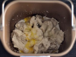 黑芝麻吐司,将中种面团撕成小块，把液体材料放入面包桶中。