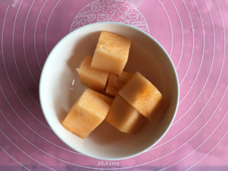 面包机版哈蜜瓜糯米糍,年糕降温的时间我们准备哈蜜瓜，把哈蜜瓜切成3厘米的小方块。