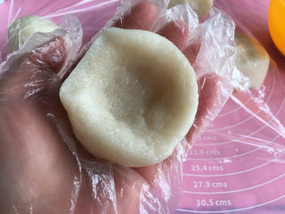 面包机版哈蜜瓜糯米糍,取出一份用手按成一个小碗形状，这样比较好放哈蜜瓜。