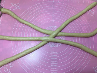燕麦辫子花环汉堡面包,然后搓成长70cm左右的长条，其它也同样方法搓成长条，取三个长条如图摆放摆好准备编辫子。