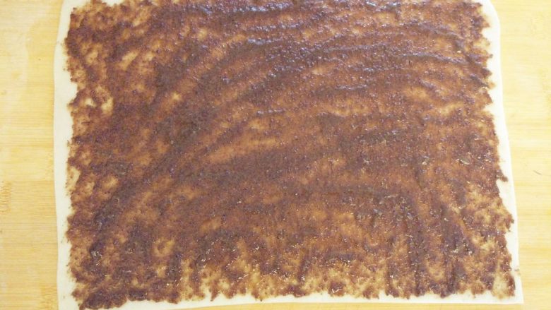 老北京麻酱糖火烧,操作板表面刷少许油，就是传统的油案，将饧好的面团擀成薄片，分点抹酱，涂匀
