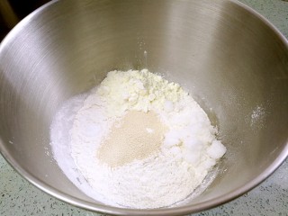 椰蓉花卷面包,把面粉、糖、盐、奶粉、酵母投入厨师机，搅拌均匀。