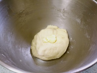 椰蓉花卷面包,用手把黄油摁入面团，继续和面。