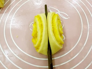 椰蓉花卷面包,取一个小面卷，用筷子在中间轻压一下。