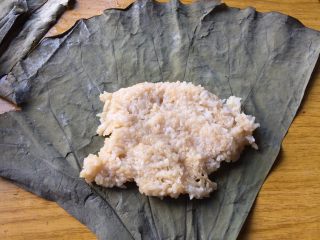 荷叶糯米鸡,在靠近荷叶尖角处，放上一勺米饭，稍稍压平