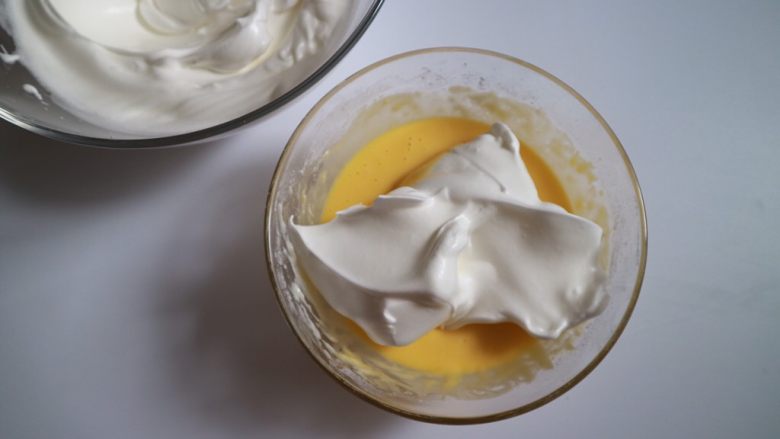 日式泡芙蛋糕卷,分两次混合蛋糊，将1/3的蛋白霜加入到蛋黄糊中翻拌均匀