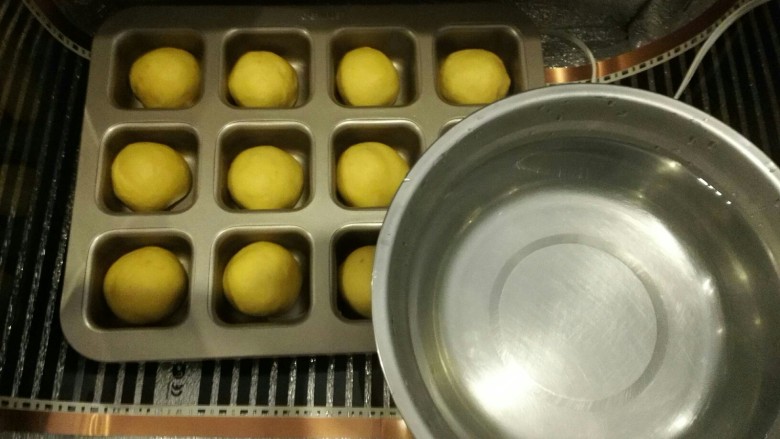 胡萝卜椰蓉菠萝巧克力豆小餐包,烤箱或者发酵箱里面放一碗热水，将模具放入，二发温度保持在38度左右，发酵到两倍大。