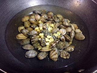 葱油花蛤,锅里注入适量清水，倒入花蛤，放入蒜末，少许料酒，盖锅盖煮开；