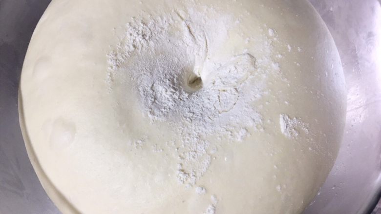咸蛋黄肉松麻薯面包,面团发酵完成，取出擀压排气、松弛。