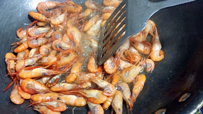 葱爆虾,锅里倒入适量的油，八成熟，倒入河虾爆炒；