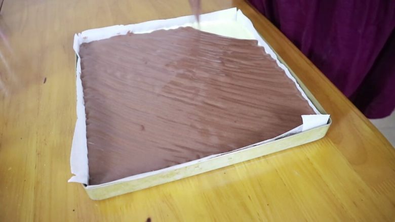 可可旋风蛋糕卷,裱花袋剪个小口，均匀的将可可面糊挤在原味面糊上