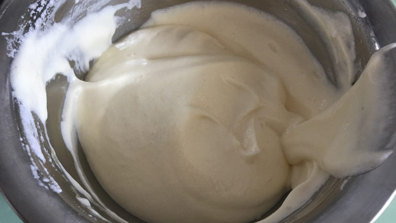 斑马纹戚风蛋糕,搅拌均匀后再加入一半的剩余蛋白，搅拌均匀 。