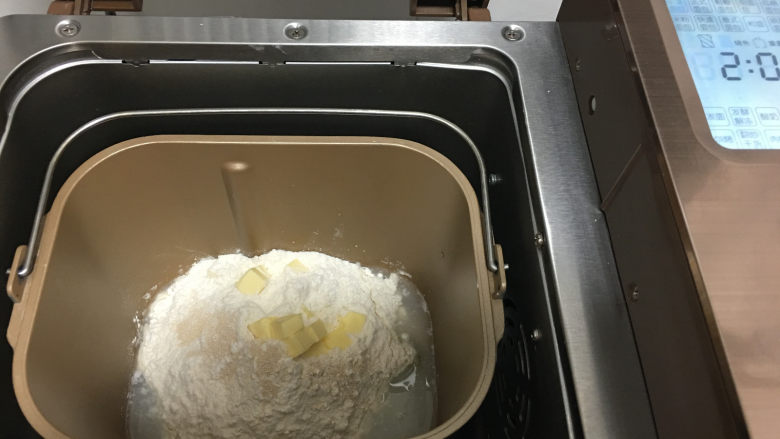 杏仁片小面包,将主面团材料一起放入面包机内，启动面包机标准面包程序进行揉面。