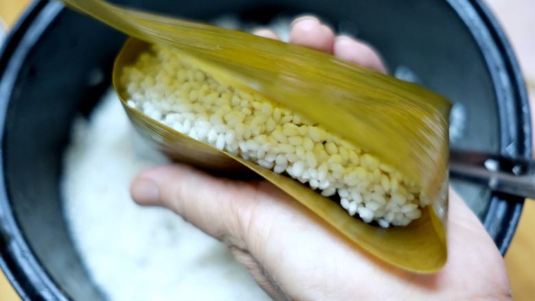 蜜枣白米甜粽,剩下2/3的粽叶往上折叠，盖住糯米。
