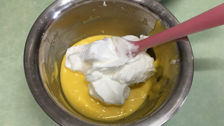 8寸原味戚风蛋糕,取1/3蛋白霜放入蛋黄糊中。（这时打开烤箱进行预热，温度为上管110度，下管150）