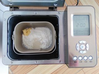 椰蓉面包卷,主配方中所有的材料放入面包桶中，酵母放面粉上，黄油放一侧角落，启动面包机和面28分钟