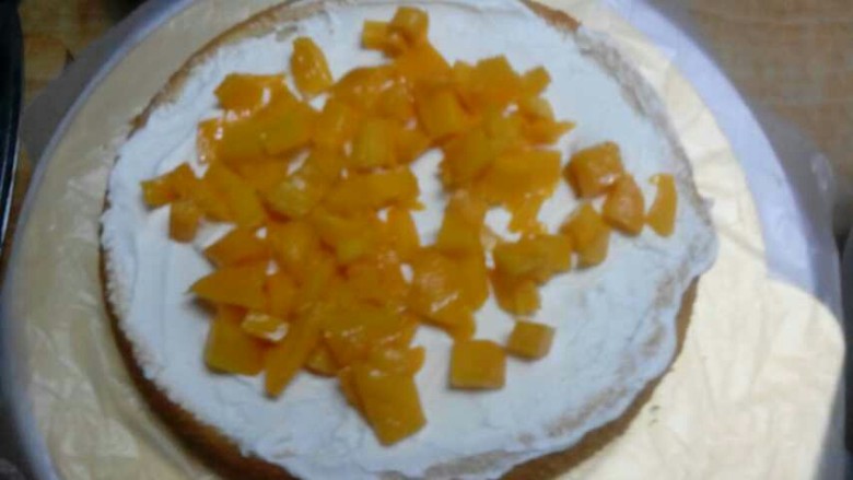 法芙娜可可水果裸蛋糕,先涂抹一层淡奶油，然后放入黄桃粒，重复这样操作。