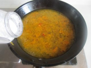 酸汤肥牛,用勺过滤下杂质， 再加入适量的盐和胡椒粉调味；