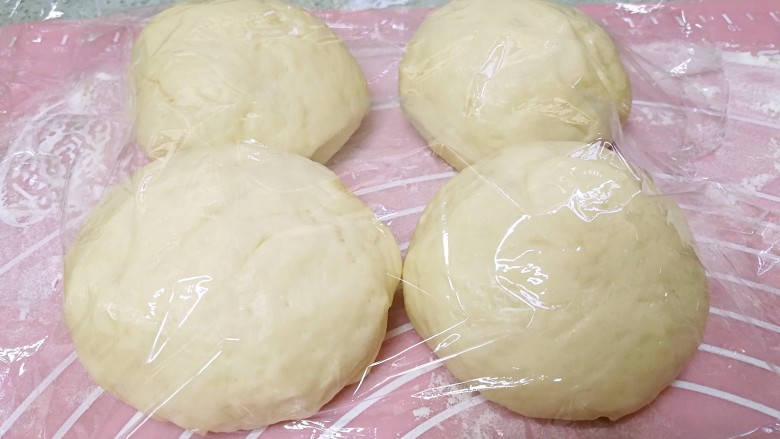 抹茶麻薯哈斯面包,把发酵好的面团按压排气后均切成4份，滚圆，盖上保鲜膜，松弛15分钟。