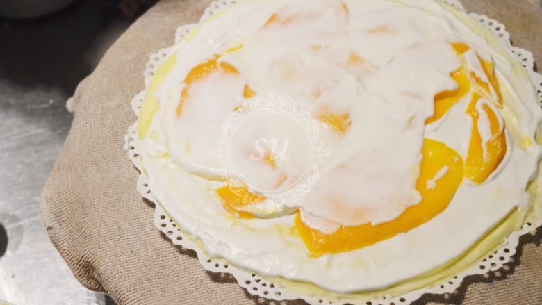 颜值与美味并存的千层蛋糕,再抹一点奶油填补芒果之间的空隙。再盖上一片饼皮