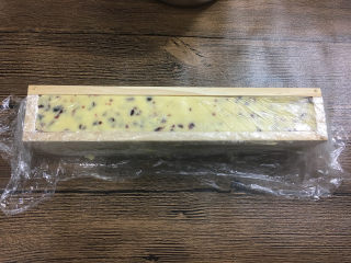 蔓越莓曲奇饼干,分一半放在保鲜膜里，然后放进长方形的蔓越莓模具中压平压实。