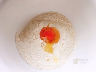 咸香芝麻饼,将中筋粉放入干净的搅拌盆内，打入鸡蛋。