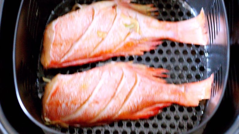 无油炸红鯛鱼,把刷好油的鱼放入预热好的炸锅里、4条鱼分两次炸、一次放两条鱼即可……