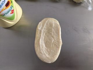 肉松面包（波兰种）,将面团擀成椭圆形，抹上蛋黄酱，留最下面不抹，压平