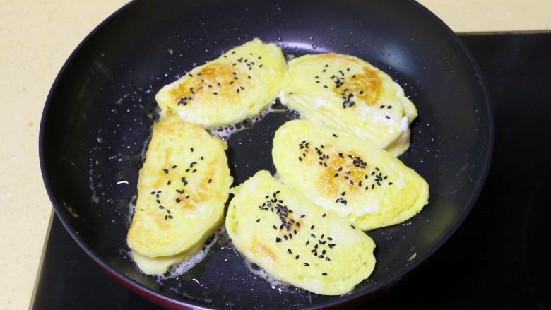 蛋煎馒头片,
翻面后，另一面也撒些黑芝麻，继续煎至金黄色即可