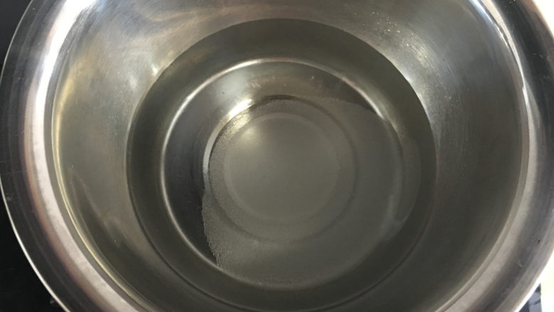 芒果水晶果冻,将纯净水和白糖放入盆中，放在燃气灶上小火加热。