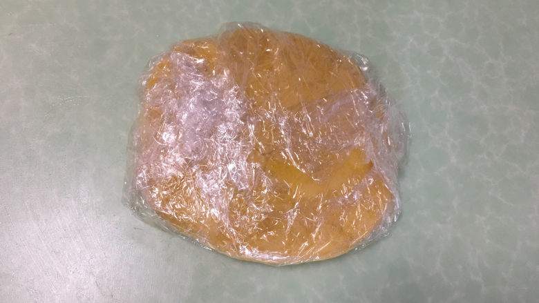 芒果、火龙果蛋挞,将面团用保鲜膜包好 ，压成圆饼形状，放冰箱冷藏30分钟。