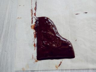 可可钢琴蛋糕,另外用微波炉融化少许黑巧克力，装入剪口裱花袋，在油纸上画出钢琴盖的形状，入冰箱冷藏至凝固。同样用白巧克力涂成长条薄片，冷藏至凝固