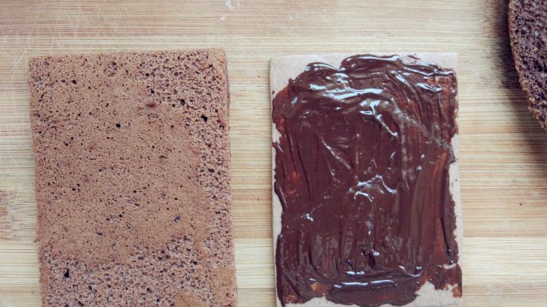 可可钢琴蛋糕,烤好的饼干取出晾凉，将蛋糕片照饼干的大小切好，在饼干上涂少许融化的黑巧克力，将薄、厚两片蛋糕片依次放在饼干上