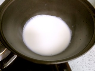 芒果雪糕,牛奶倒入奶锅，小火加热至四周边上冒细泡。