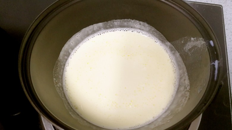 芒果雪糕,把牛奶蛋黄液倒回奶锅，小火加热至微沸，边加热边搅拌，离火晾凉备用。