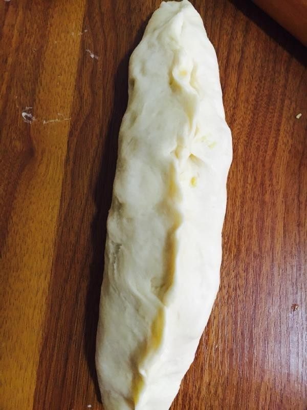 奶黄面包,擀成扁平条状包入奶黄馅。