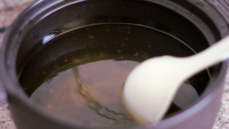 砂锅丸子粉丝汤,倒入三分之一包火锅底料、半勺盐，盖上盖子，启动程序烧开水。