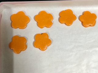 黄金芝士太阳花饼干,转移到铺了油纸的烤盘里。