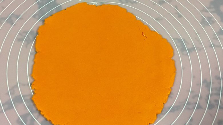 黄金芝士太阳花饼干,擀成0.4厘米厚的面片。